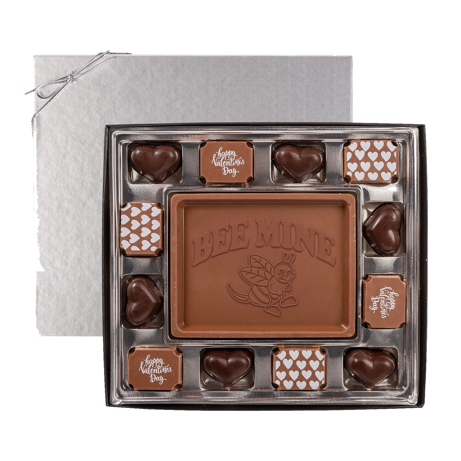 The Honey Revenge Swiss chocolate Valentine’s Day gift box features a large square “Bee Mine” piece with a bee illustration, surrounded by heart-shaped and square chocolates with festive Valentine’s designs.